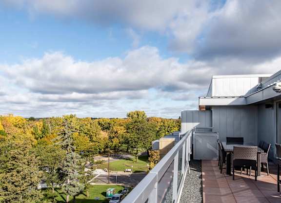 Rooftop terrace with dining area and tree views at 1800 Lake Apartments, Minnesota, 55408