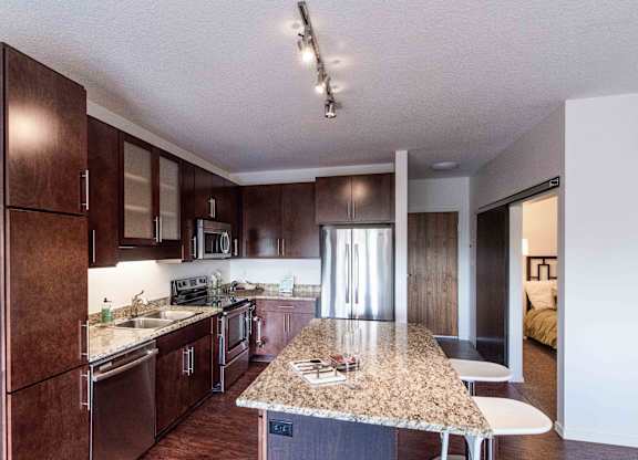 Modern kitchen island with granite countertop and seating at 1800 Lake Apartments, Minneapolis, MN 55408
