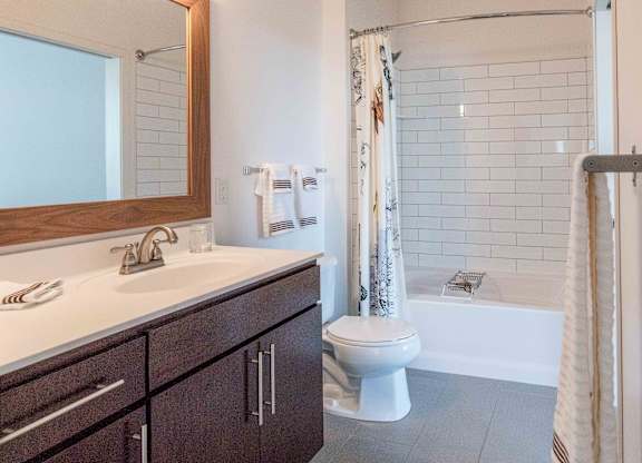 Bathroom with subway tile and dark vanity at 1800 Lake Apartments, Minneapolis