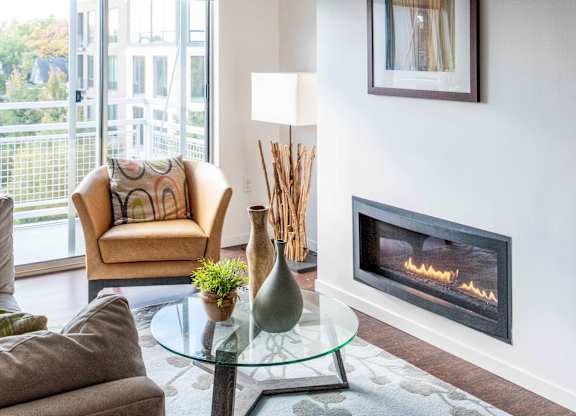 Living room with modern fireplace and glass coffee table at 1800 Lake Apartments, Minneapolis, MN 55408