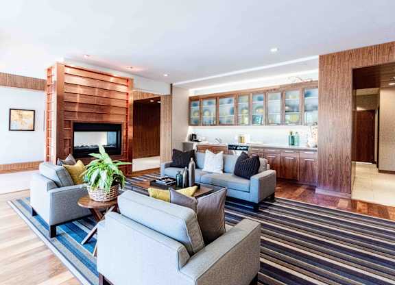 Lobby lounge with fireplace and striped area rug at 1800 Lake Apartments, Minneapolis