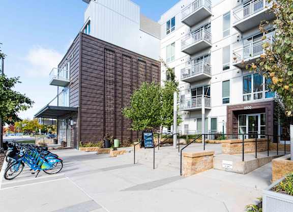Bike share station and apartment building exterior at 1800 Lake Apartments, Minnesota, 55408