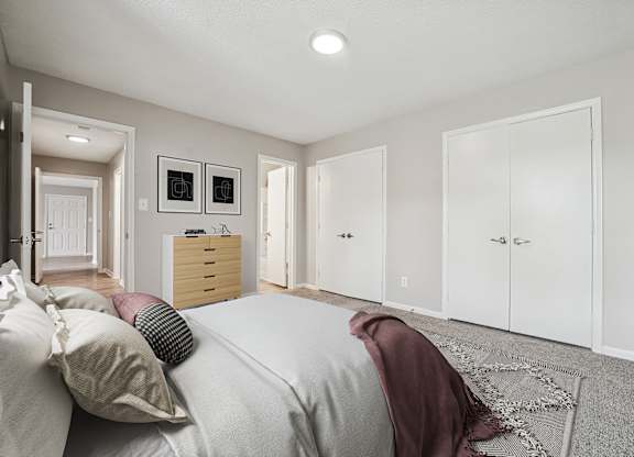 A bedroom with a bed, a dresser, and a wardrobe.