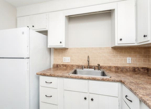 a kitchen with white cabinets and a sink at Stonebridge, Ellington