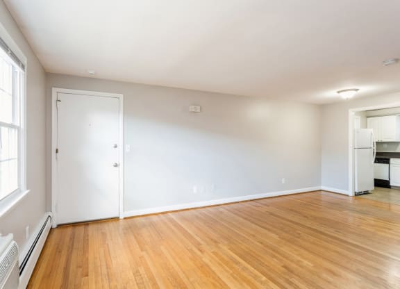 a living room with a wood floor and a white wall with geometric patterns on it