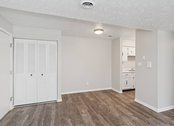 A room with a white door and wooden flooring.