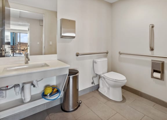 a bathroom with a toilet and a sink and a mirror at The Rowe, Grand Rapids, MI