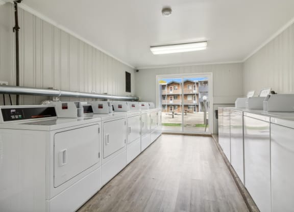 laundry room with washer and dryers and a door to a building in the at River Oaks, North Aurora, IL, 60542