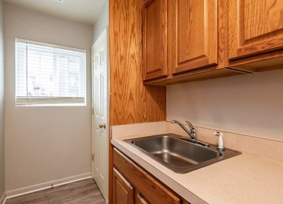 A kitchen with wooden cabinets and a white sink.