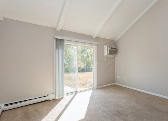 a curved room with a window and white walls wiht sliding doors