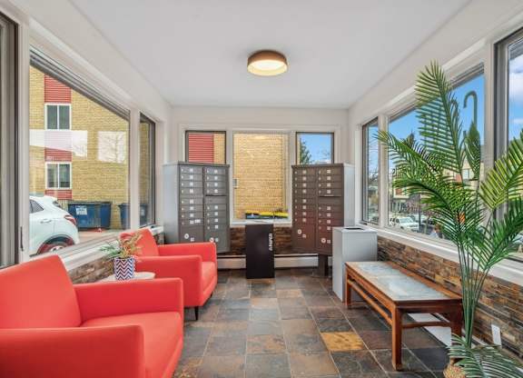 A room with red chairs and a wooden bench.