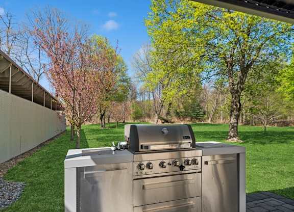 A stainless steel outdoor grill is on a patio.