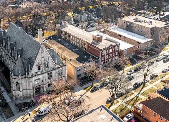 A large building with a tower is surrounded by other buildings at Pleasant Oak Apartments, Oak Park, Illinois