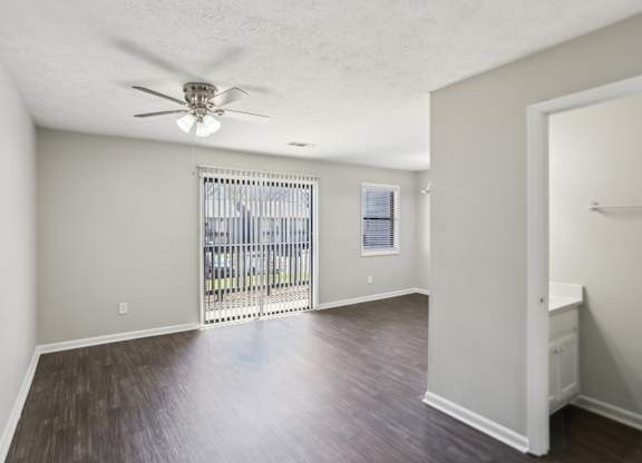 A room with a sliding door and a ceiling fan.