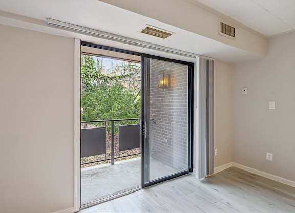 A modern interior with a sliding glass door leading to a balcony.