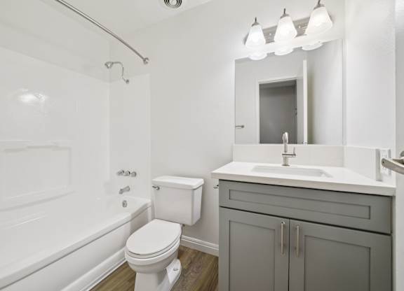 A white toilet sits next to a white sink in a bathroom.