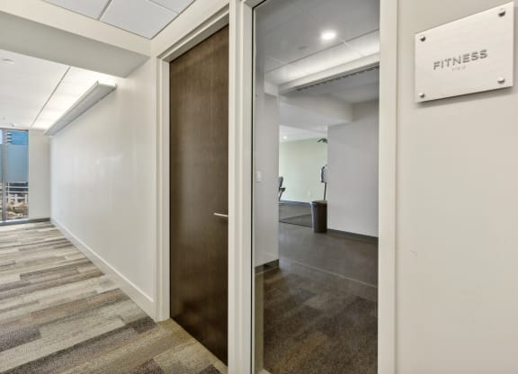 a hallway with white walls and a wooden door at The Rowe, Grand Rapids, MI