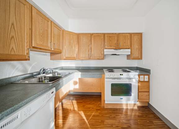 A kitchen with wooden cabinets and a stove top oven.