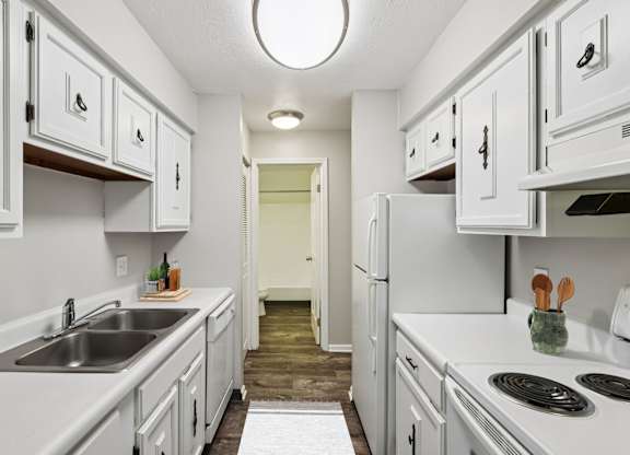 A kitchen with white cabinets and appliances.