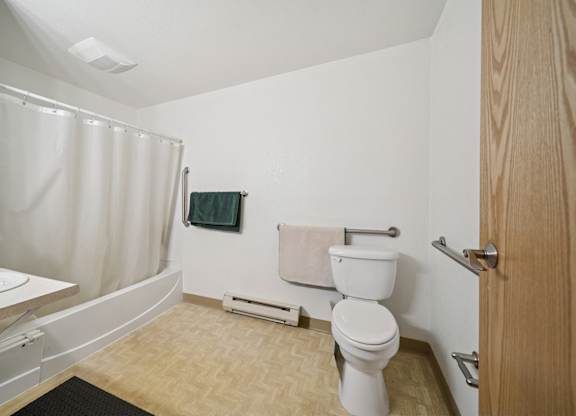 A bathroom with a toilet, sink, and shower.