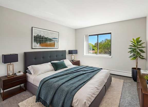 A bedroom with a large bed and a painting on the wall.
