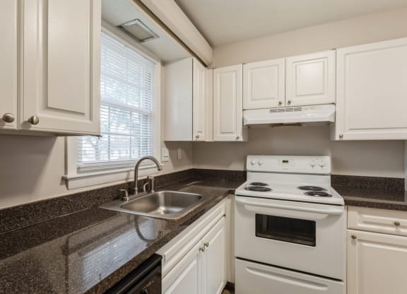 a kitchen with white appliances and granite counter tops