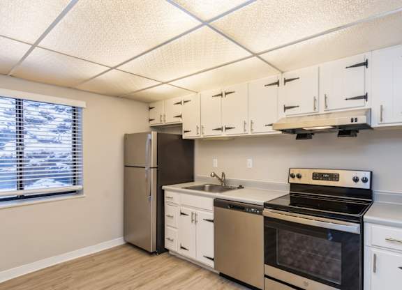 A kitchen with white cabinets and stainless steel appliances.