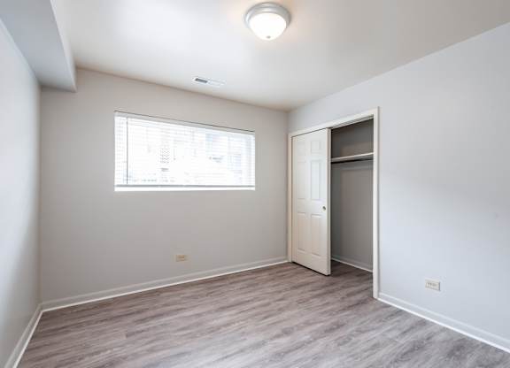 A room with a window and a door is empty and waiting to be furnished.
