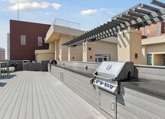 A grill is on a wooden deck.