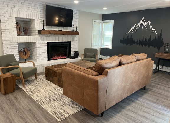 Club house with a white brick fireplace and a couch and a TV