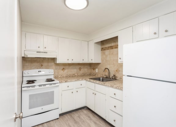 a kitchen with white appliances and white cabinets at Stonebridge, Ellington, CT