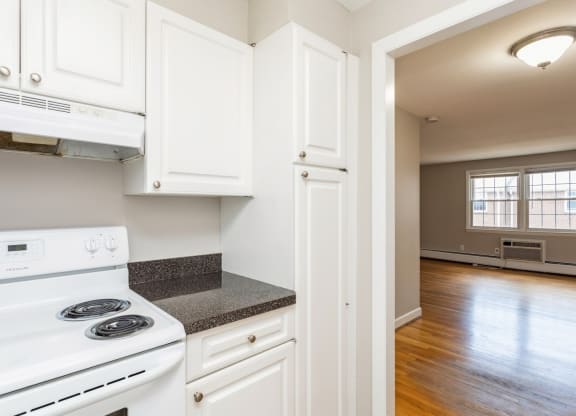 an empty kitchen with white appliances and white cabinets
