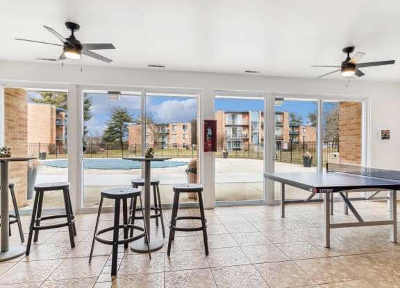 Open room with a pool and tables and ceiling fans at The Reserve on Washington, Illinois