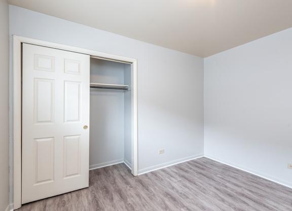 A white door is open to a room with a grey floor.