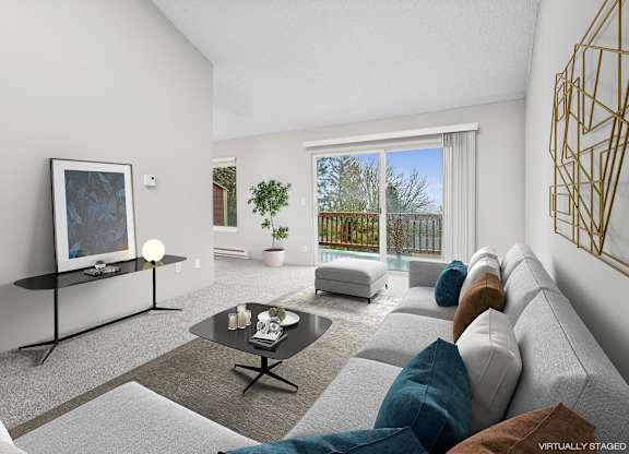 A modern living room with a grey sofa, a black coffee table, and a large window.