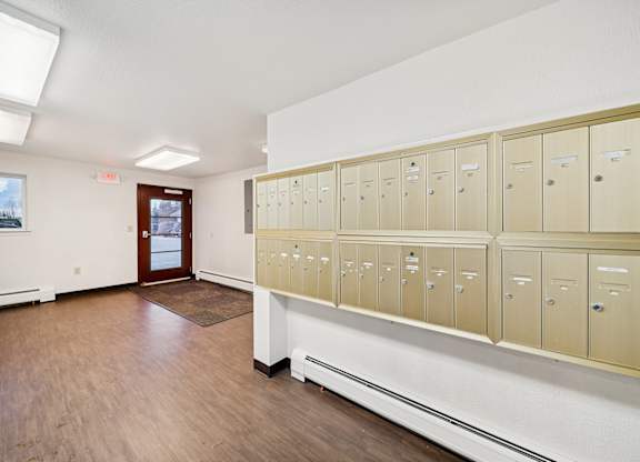 A row of lockers in a room with a door on the left.