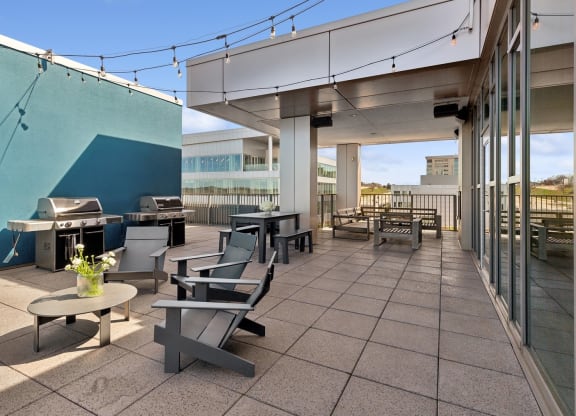 a patio with tables and chairs and a grill on the side of a building at The Rowe, Michigan