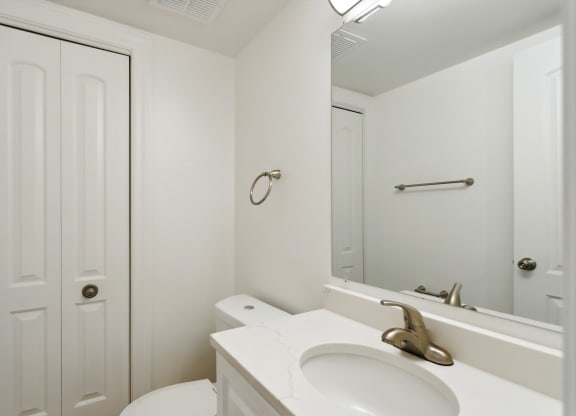 a bathroom with a white sink and toilet next to a white door at The Hinsdale, Hinsdale, Illinois