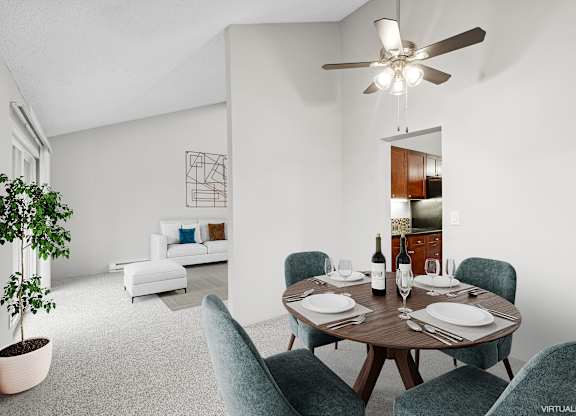 A dining room with a table set for two and a potted plant.