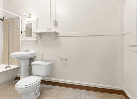 A bathroom with a toilet and mirror.
