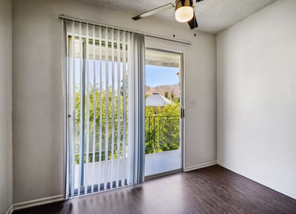 an empty living room with a door to a balcony