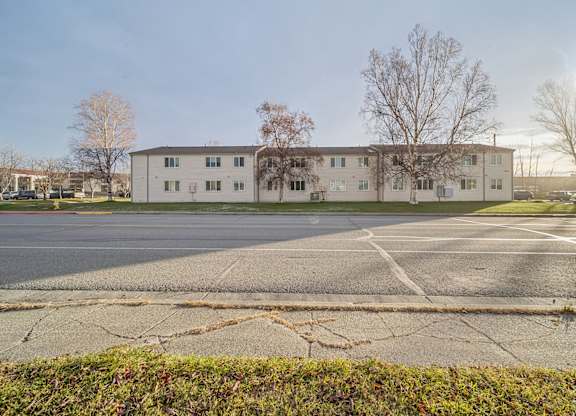 A large white building with a parking lot in front.