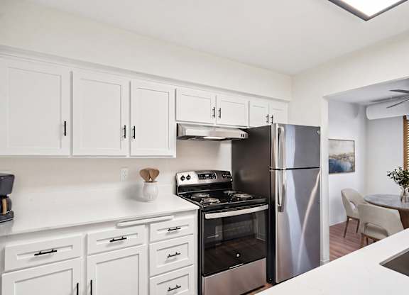 A kitchen with white cabinets and stainless steel appliances.