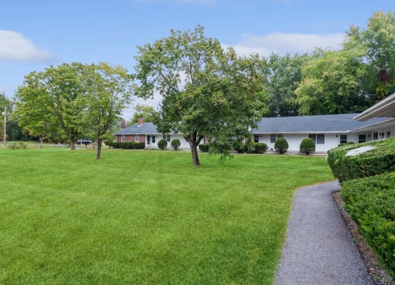 a house with a lawn and trees in front of it