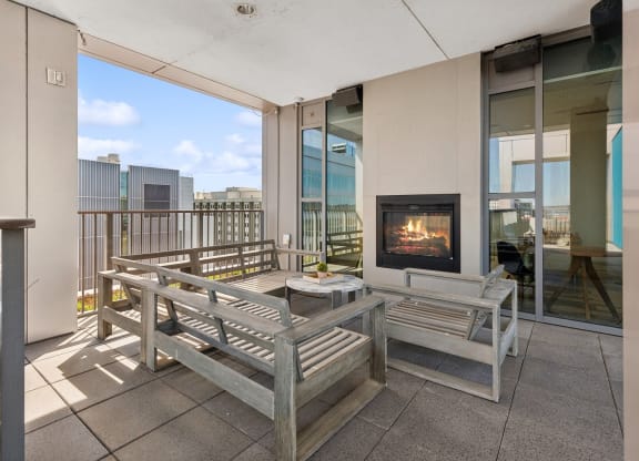 a living room with a fireplace and wooden benches at The Rowe, Grand Rapids, MI