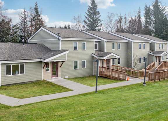A row of houses with a green lawn in front.