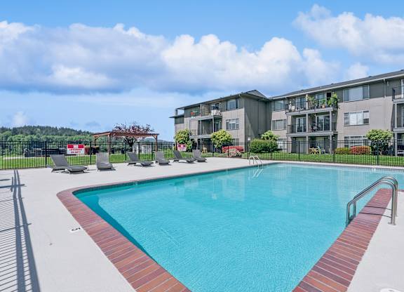 A swimming pool in front of apartment buildings.