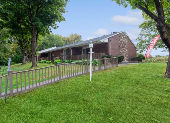 a house with a fence and a yard in front of it