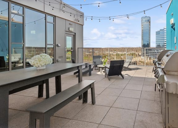 a dining area with a table and chairs on a balcony at The Rowe, Grand Rapids, 49503