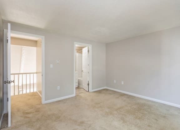 an empty living room with a door to hallway and closet